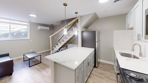 A kitchen with a staircase leading to the upper floor.